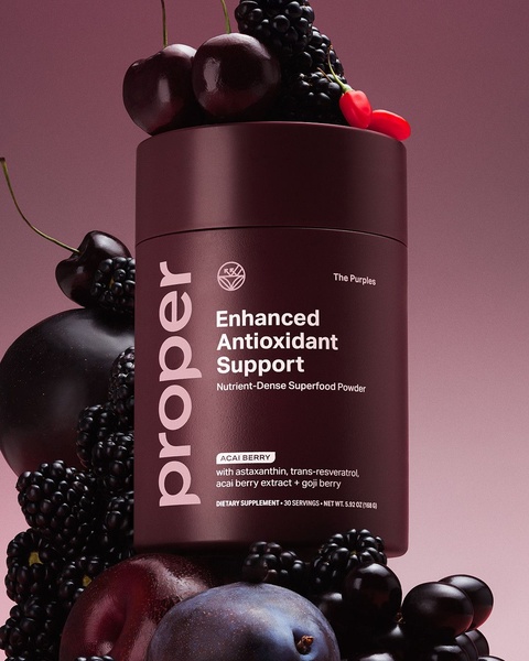A high-end, studio-lit shot of a superfood supplement container surrounded by fresh, dark-toned berries, emphasizing premium ingredient quality.